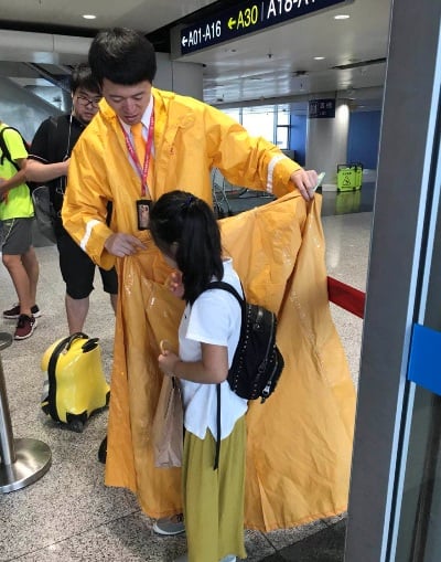 劉元全幫助小旅客穿雨衣.jpg