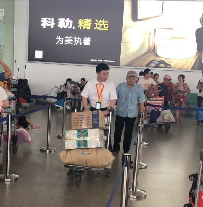 鄧興鵬幫助旅客推行李(攝影:劉啟民).jpg