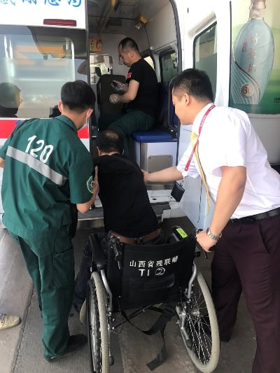 侯帥將旅客扶上急救車.jpg
