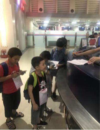 四名小旅客在柜臺邊圍著“超級奶爸”.jpg
