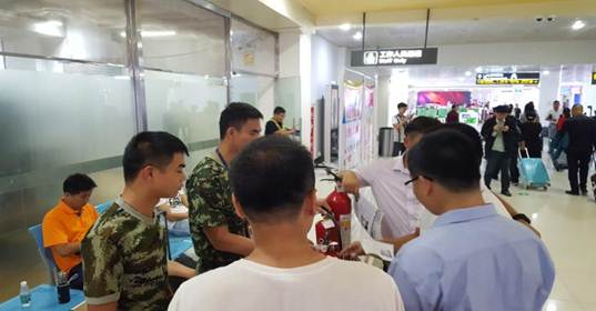 配圖:鳳凰機(jī)場消防支隊(duì)隊(duì)員為過往旅客和機(jī)場員工示范滅火器的使用方法.jpg