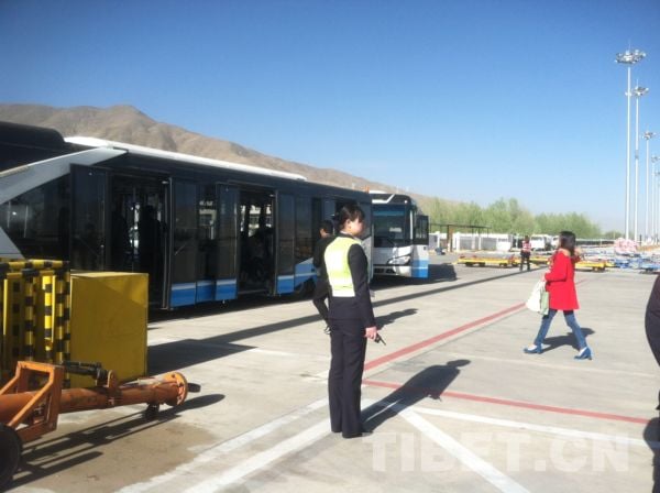 機場工作人員在指引旅客登上機場擺渡車