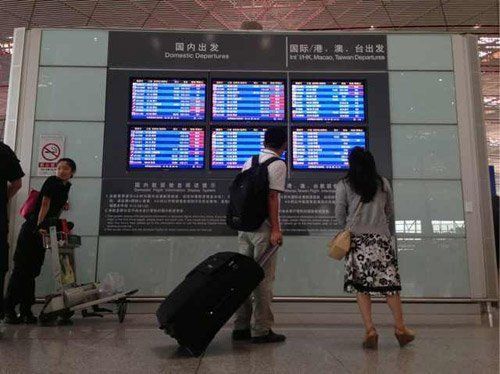 T3航站樓內旅客在看航班信息 新京報記者 薛珺 攝